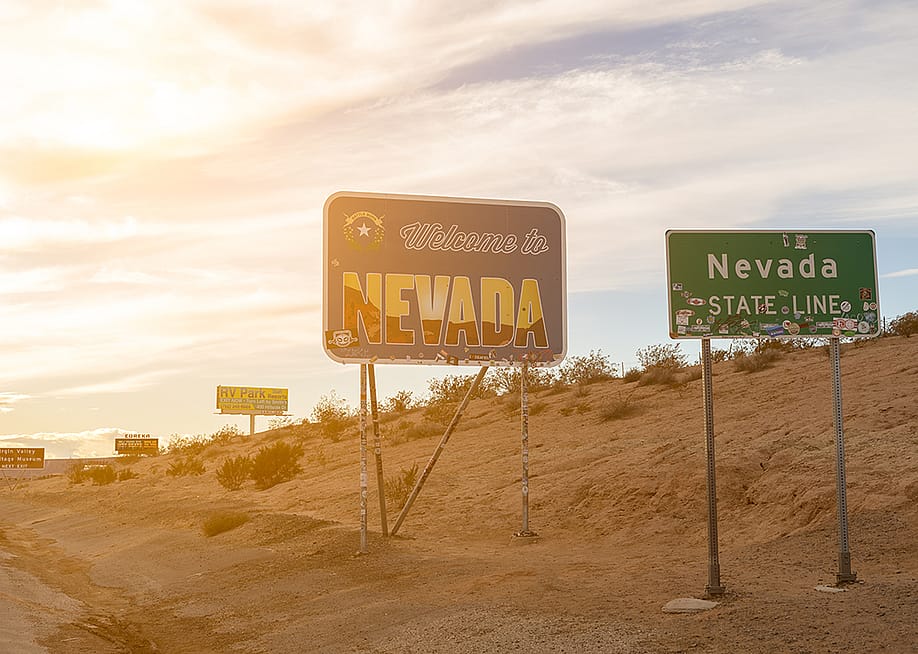 A 'Welcome to Nevada' signage during sunset. — Kirkam // Shutterstock
