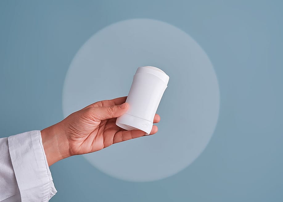 A hand holding a deodorant stick. — marevgenna // Shutterstock