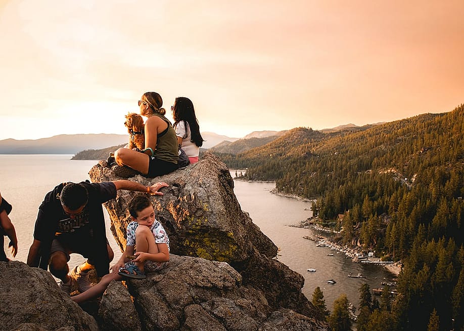 A family enjoying the sunset view of Lake Tahoe from atop Cave Rock. — oliverdejonghe // Shutterstock