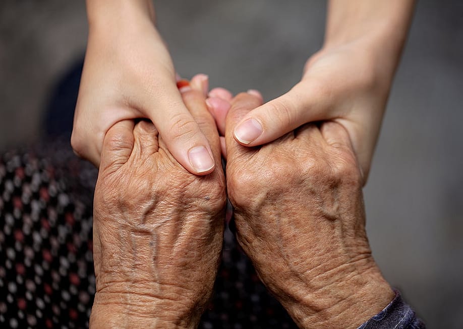 Hands of an old and young persons as a concept of assisting older generation. — edahymn // Shutterstock