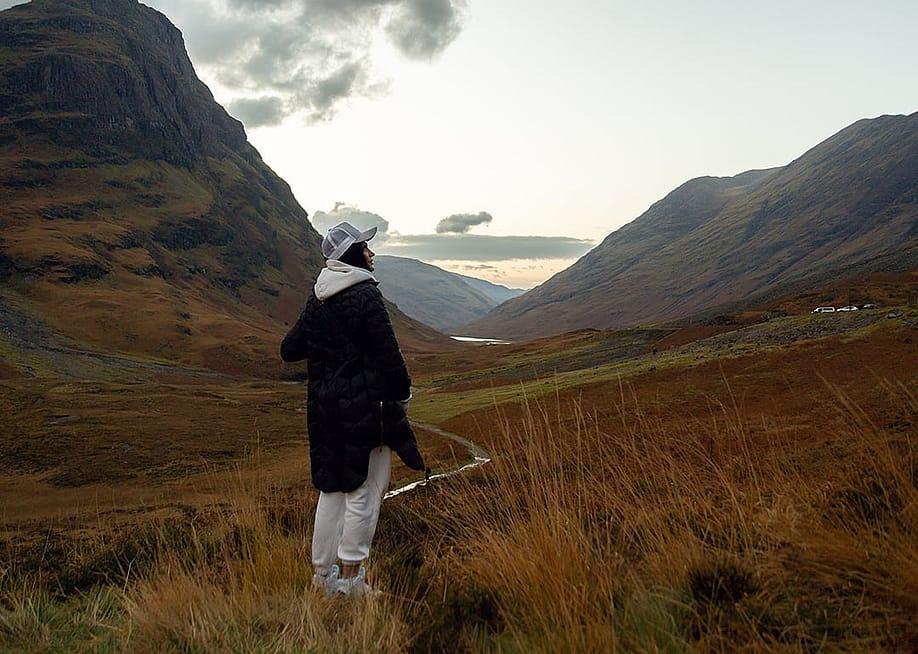 A woman enjoying the view of the majestic Scottish highlands. — Misha Beliy // Shutterstock