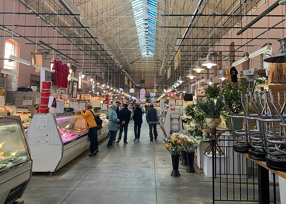 A local neighborhood's customers make retail purchase from butchers inside Eastern Market in Washington, DC. — 010110010101101 // Shutterstock