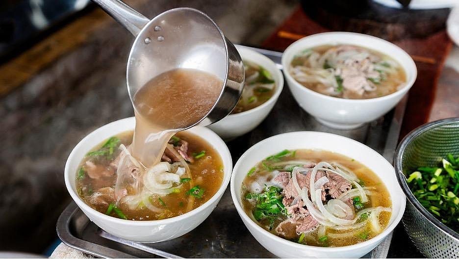 A rich broth ladled onto bowls of Pho.