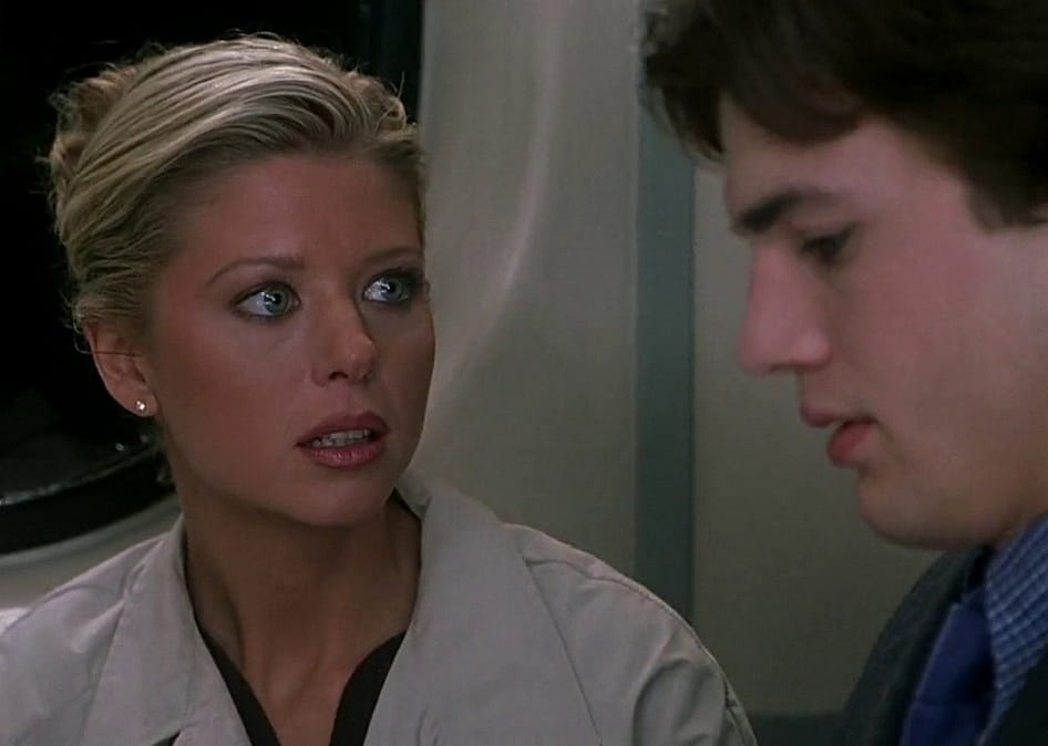 Tara Reid looks seriously at Ashton Kutcher.