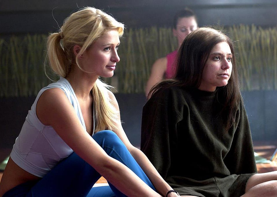 Paris Hilton sitting next to an ugly girl.